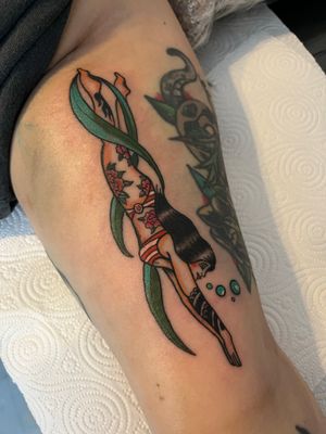 Neo-traditional tattoo of a woman diver surrounded by plants, by Claudia Vicente. A unique and vibrant piece!