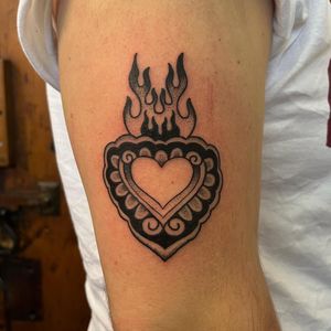 This traditional dotwork tattoo features a sacred heart motif, beautifully executed by the talented artist Claudia Vicente.