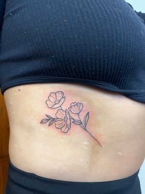 Elegant fine line and illustrative design featuring a beautiful flower and branch, expertly crafted by tattoo artist Claudia Vicente.