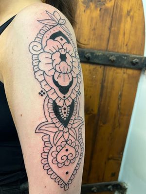Experience the intricate beauty of this geometric, ornamental, and illustrative tattoo featuring a stunning flower mandala design by talented artist Claudia Vicente.