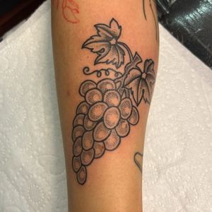 Unique grape tattoo in dotwork and traditional style by Claudia Vicente.