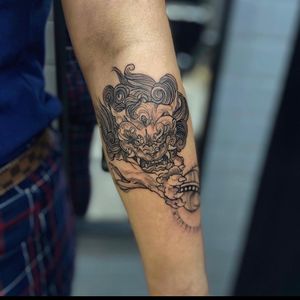 Experience the timeless art of Japanese woodcut with this illustrative tattoo of a fierce foo dog by the talented artist Holly Valley.