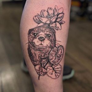 Experience the beauty of nature with this stunning neo_traditional tattoo featuring an otter and delicate flower by Holly Valley.