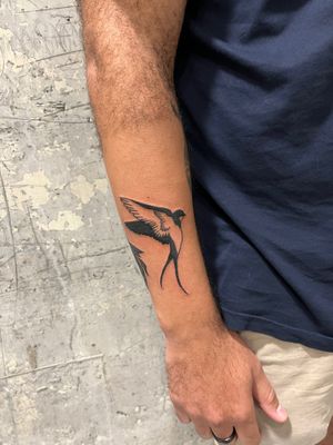 Experience the timeless beauty of a traditional swallow bird tattoo by renowned artist Dave Norman. Perfect for those seeking a classic and illustrative design.