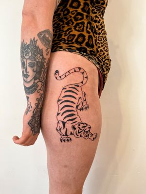 Get a fierce and powerful traditional tiger tattoo done by the talented artist Dave Norman, featuring bold lines and vibrant colors.