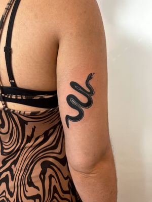 Experience the bold and timeless style of traditional blackwork with this ignorant snake design by Dave Norman.