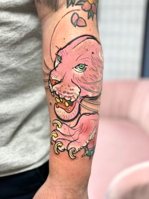This illustrative tattoo features a fierce panther in vibrant pink hues, expertly crafted by tattoo artist Hannah Keuls.