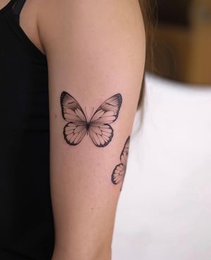 Elegant black and gray butterfly tattoo on the upper arm, crafted by Ion Caraman.