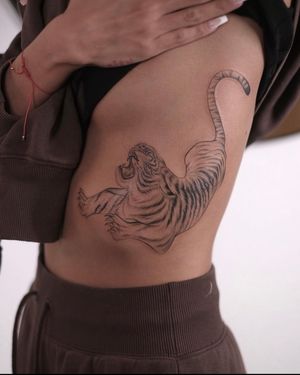 Embrace the fierce beauty of a fine line illustrative tiger tattoo crafted by the talented artist Ion Caraman.