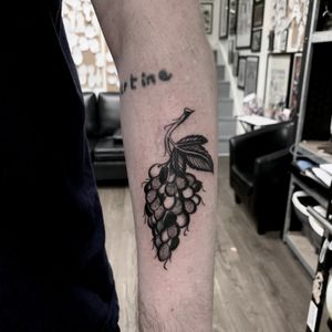 Celebrate abundance with this stunning tattoo by Ludo Matmut featuring beautifully detailed grapes in illustrative traditional style.