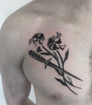 Get inked with a stunning illustrative tattoo featuring a beautiful flower and a sharp dagger, masterfully done by talented artist Ludo Matmut.