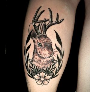 Embrace the beauty of nature with this stunning illustrative tattoo of a jackalope and floral fauna by the talented artist Ben Twentyman.
