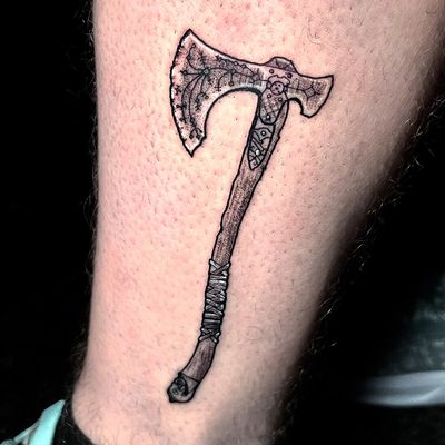 This dotwork tattoo features a detailed depiction of the Leviathan Axe from God of War, expertly executed by tattoo artist Ben Twentyman.