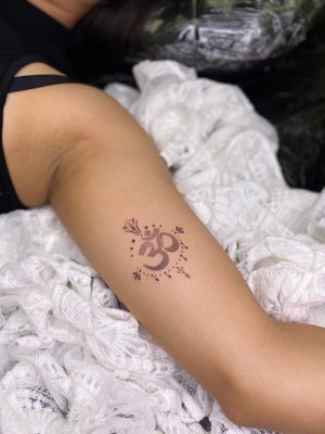 Embrace tranquility with this dainty ornamental dotwork tattoo featuring the sacred ohm symbol. Designed by Viví Bogdanov.