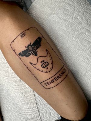 Get a minimal, illustrative tattoo inspired by Silence of the Lambs with small lettering by Miss Vampira. A haunting tribute to Hannibal Lecter.
