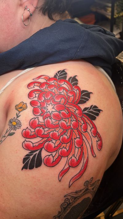 Exquisite Japanese tattoo featuring a beautiful chrysanthemum flower, expertly done by artist Claudia Vicente.