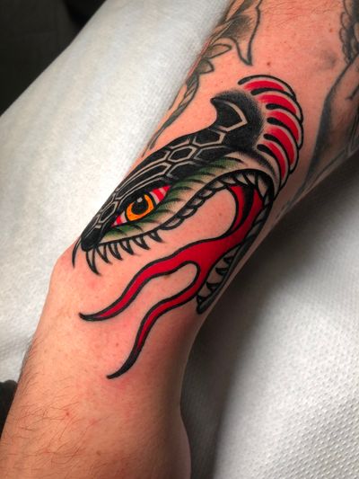 Experience the artistry of Angel Face with this traditional snake tattoo. Bold lines and vibrant colors make for a striking design.