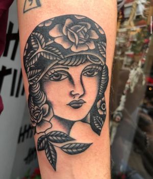 A stunning black and gray traditional tattoo featuring a beautiful woman, expertly done by Angel Face.