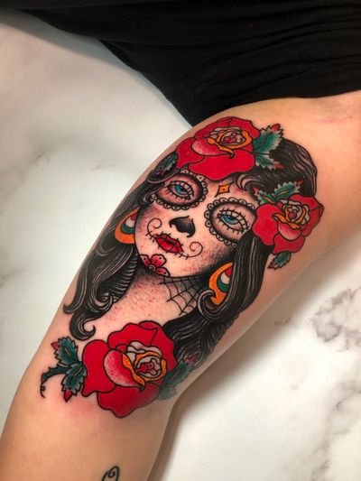 Embrace the beauty of life and death with this stunning tattoo by Angel Face, featuring a bold mix of flowers, sugar skull, and a mysterious woman.