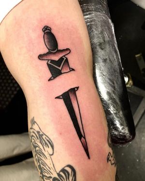 Get a classic traditional dagger tattoo by the talented artist Angel Face. Embrace the bold, timeless style of traditional tattooing with this striking design.