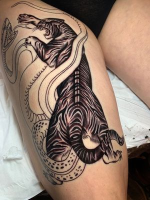 Traditional black and gray tattoo by Angel Face featuring a fierce snake and tiger design.
