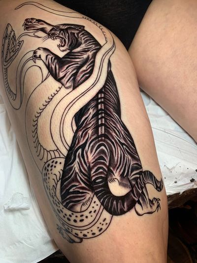 Traditional black and gray tattoo by Angel Face featuring a fierce snake and tiger design.