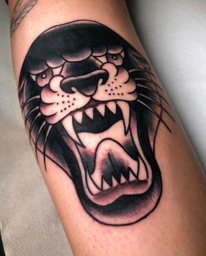 Get a bold and fierce traditional panther tattoo by renowned artist Angel Face. Stand out with this timeless and powerful design.