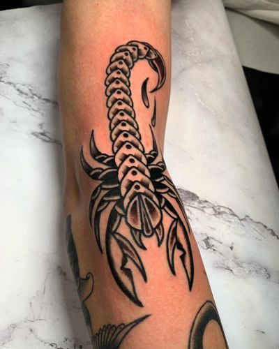 Get inked by Angel Face with a fierce traditional scorpion design, perfect for those seeking a bold and timeless tattoo.