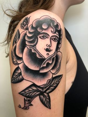 Capture the beauty of a woman and a rose in a stunning black and gray traditional style tattoo by Angel Face.