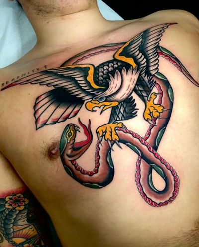 Get inked with a striking traditional tattoo featuring a menacing snake and majestic eagle by Angel Face.