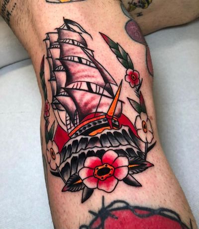 Get inked by Angel Face with this classic design featuring vibrant flowers and a sailing ship.