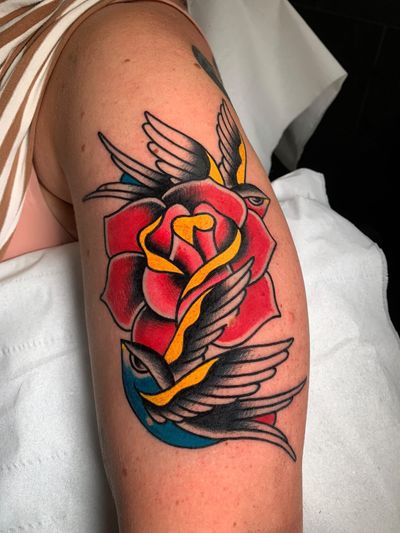 Beautiful traditional tattoo featuring a swallow, flower, and rose design by Angel Face.
