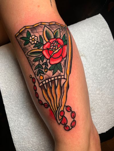 Get inked with a stunning illustrative design featuring a beautiful rose and fan, expertly crafted by tattoo artist Angel Face.
