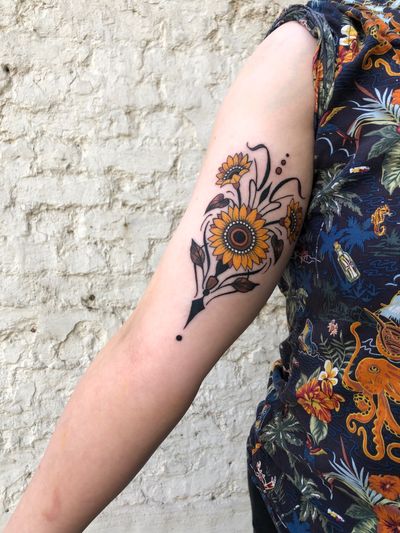 Get a stunning neo-traditional sunflower tattoo by Elena Mameri, inspired by art nouveau and art deco styles.