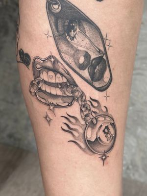 Stunning black and gray tattoo by Laura May featuring a metallic lip design with an eight ball and chain motif in dotwork and illustrative style.