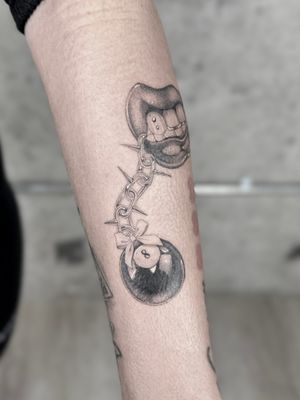 Laura May's stunning black and gray tattoo features an illustrative keychain with an eight ball and chain design, perfect for pool lovers. Incorporating dotwork for added depth and detail.