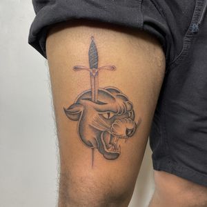 Capture the fierce beauty with this black_and_gray traditional tattoo by Charlie Macarthur. Featuring a striking panther and dagger motif.