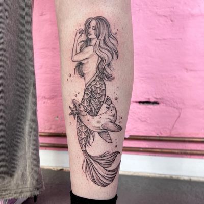 Get mesmerized by Hannah Senoj's unique mermaid and seal tattoo design, combining fantasy and ocean vibes.