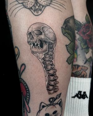 Unique illustrative design featuring a skull, spine, and skeleton intricately done in dotwork style by talented artist Kat Jennings.
