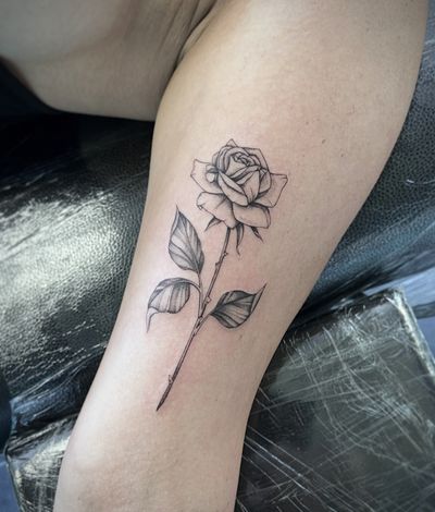 Beautifully detailed floral tattoo featuring a realistic rose, expertly crafted by artist Hannah Senoj.