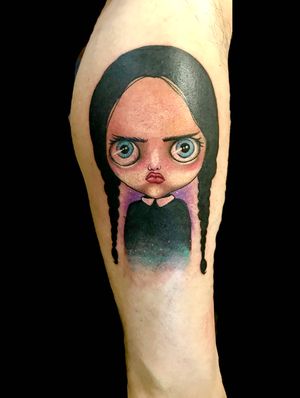 Get a hauntingly beautiful tattoo of Wednesday Addams from the Adam's Family, done in a stunning watercolor illustrative style by Eve Inksane.