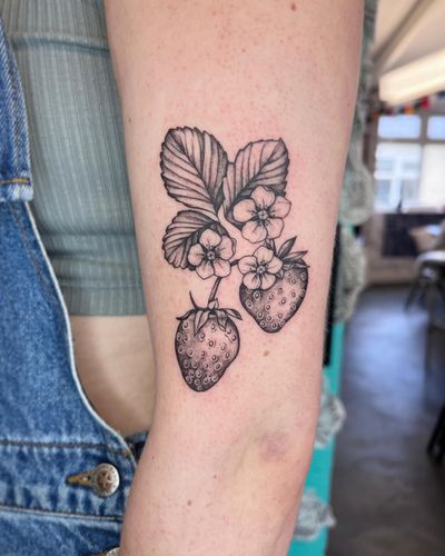 Vibrant and detailed tattoo featuring a beautiful blend of strawberries and flowers, crafted by the talented artist Hannah Senoj.