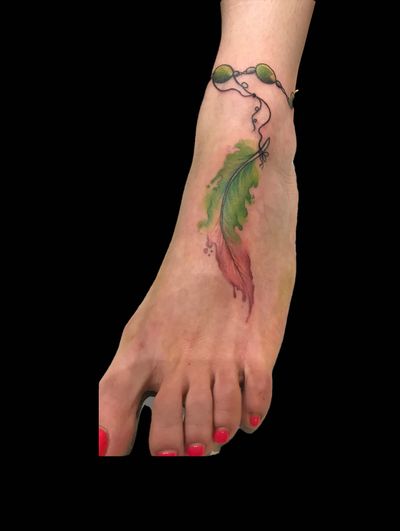 Experience the beauty of watercolor with this illustrative feather tattoo by the talented artist Eve Inksane.