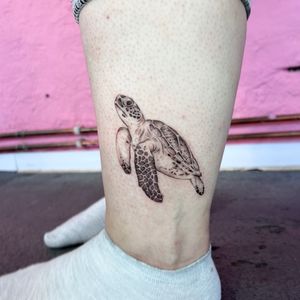 Get mesmerized by Hannah Senoj's illustrative sea turtle tattoo, a true work of art.
