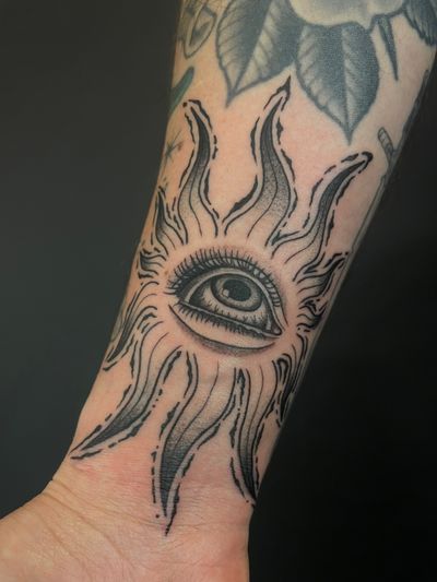 Illustrative tattoo featuring a unique combination of a sun and an eye, expertly done by Kat Jennings in dotwork style.
