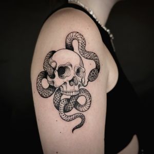 Unique dotwork style tattoo featuring a snake intertwining with a skull, tattooed by Jenny Dubet.