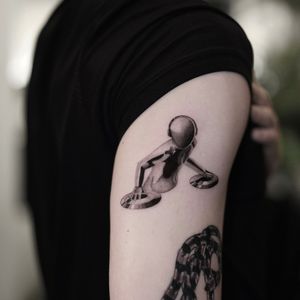 Gloria Gu's black and gray illustrative tattoo of a metallic DJ in chrome, capturing the essence of music and technology.