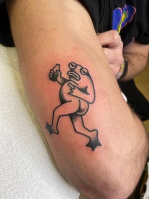 Get a whimsical and bold frog tattoo in traditional ignorant style by the talented Goblyn Crew. Perfect for those who love unique and eye-catching body art.