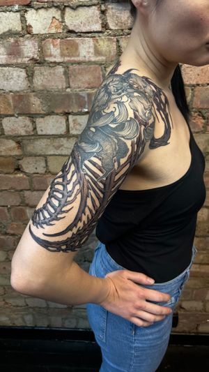 Embrace the beauty in darkness with this stunning blackwork, dotwork, and illustrative tattoo featuring a unique combination of flowers and bones by the talented artist Misa.