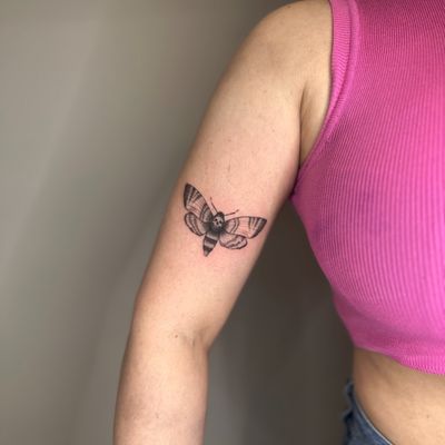 Experience the delicate beauty of a black and gray illustrative moth tattoo by the talented artist Tas Kal. Perfect for those seeking a mystical and unique design.